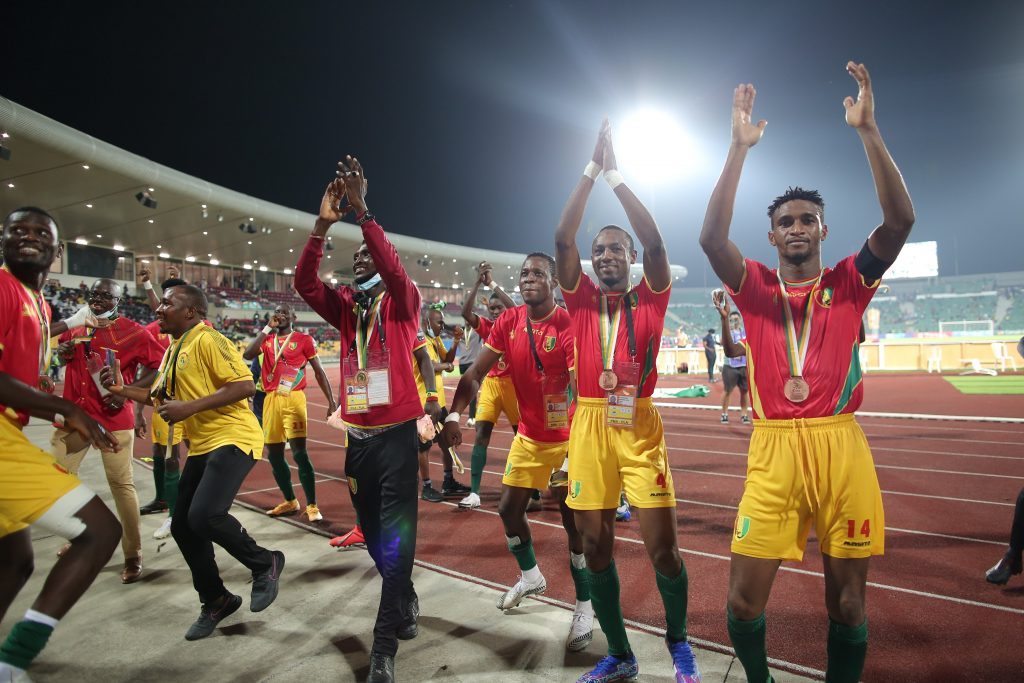 Guinea players celebrating in front of their fans. 