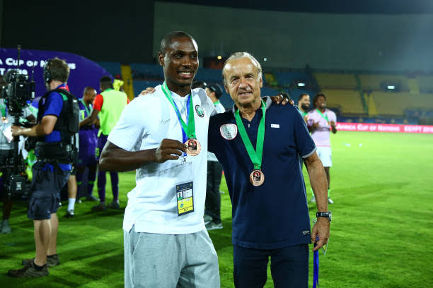 Odion Ighalo wearing the AFCON 2019 Bronze medal alongside Gernot Rohr.