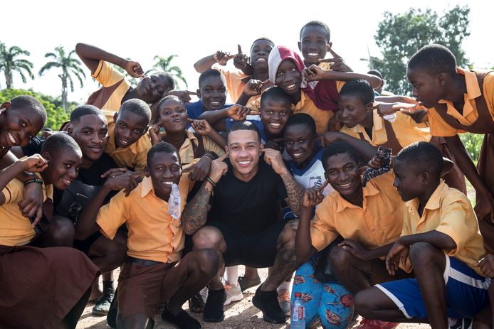 Memphis Depay surrounded by students in Cape Coast (2019).