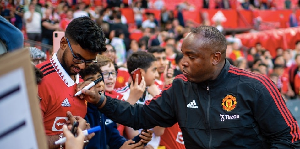 Benni McCarthy signing autographs for Man United fans.